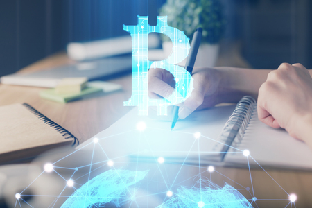 Cryptocurrency hologram, bitcoin, ico theme over hands taking notes background. Concept of blockchain. Multi exposureの写真素材