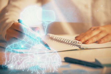 AR hologram over hands taking notes background. Concept of augmented reality. Double exposureの写真素材