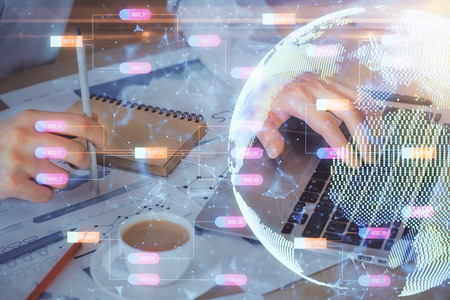 Double exposure of world map hologram with man working on computer on background. Concept of...