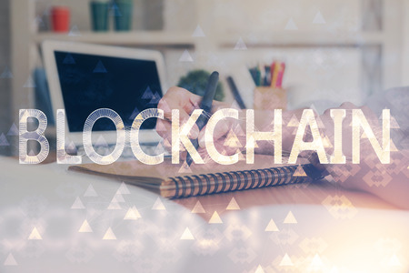 Cryptocurrency hologram over hands taking notes background. Concept of blockchain. Multi exposureの写真素材