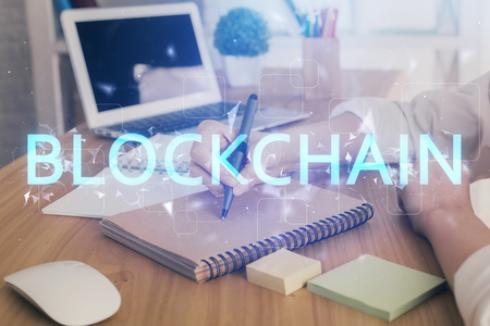 Cryptocurrency hologram, bitcoin, ico theme over hands taking notes background. Concept of blockchain. Multi exposureの写真素材