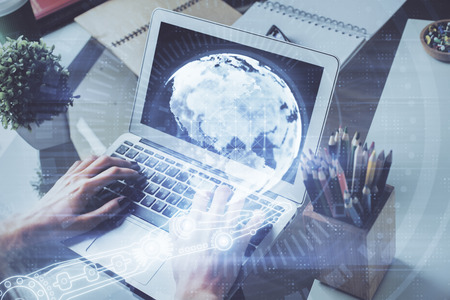 Double exposure of world map hologram with man working on computer on background. Concept of worldwideweb.の写真素材