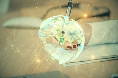 Social network theme hologram over hands taking notesの写真素材