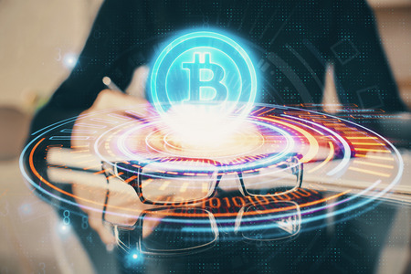 Cryptocurrency hologram over woman's hands writingの写真素材