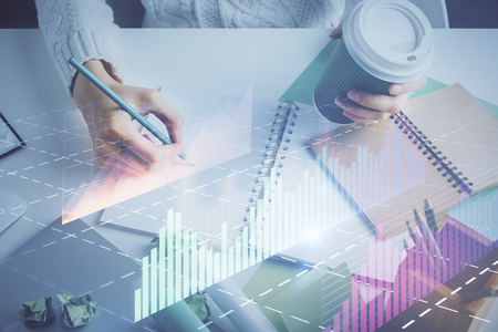 Financial forex graph displayed on hands taking notes background. Concept of research. Multi exposureの写真素材