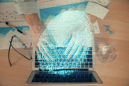 Fingerprint hologram with businessman working on computer on background. Security concept. Double exposure.の写真素材