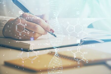 DNA theme hologram over womans hands writing background. Concept of education. Double exposureの写真素材