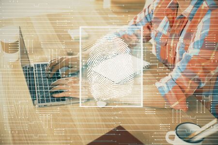 Fingerprint hologram with businessman working on computer on background. Security concept. Double...