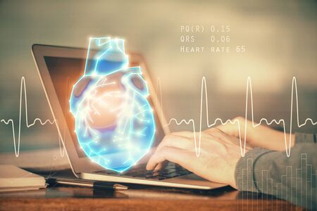 Heart drawing with man working on computer on background. Medical concept. Double exposure.の写真素材