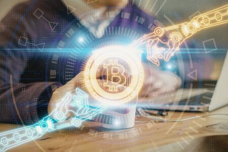 Crypto currency theme hologram with businessman working on computer on background. Concept of...