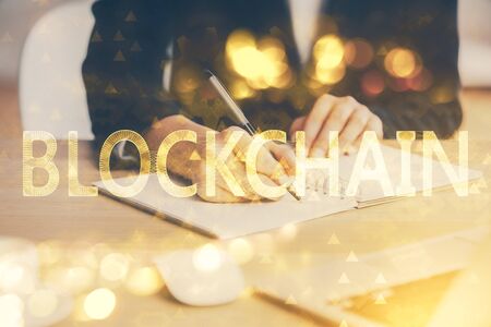 Cryptocurrency hologram over hands taking notes background. Concept of blockchain. Multi exposureの写真素材