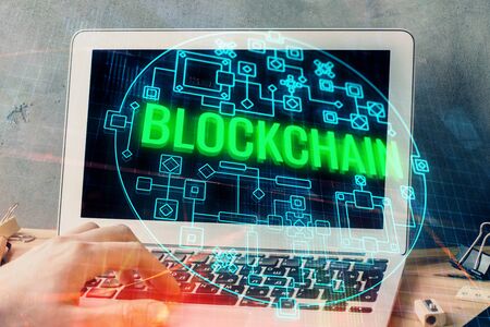 Crypto currency theme hologram with businessman working on computer on background. Concept of blockchain. Double exposure.の写真素材