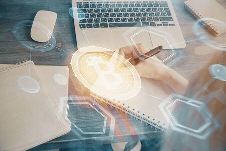 Cryptocurrency hologram over hands taking notes background. Concept of blockchain. Multi exposureの写真素材