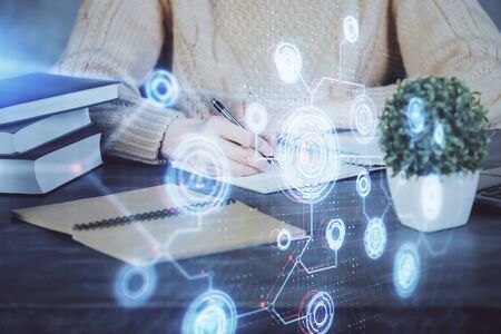 Double exposure of writing hands on background with data solution hologram on front. Technology concept. Close upの写真素材