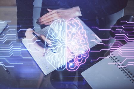 Double exposure of writing hand on background with brain hologram. Concept of learning.