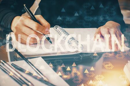Cryptocurrency hologram over hands taking notes background. Concept of blockchain. Multi exposure