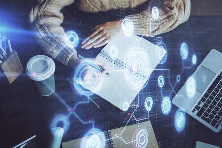 Double exposure of writing hands on background with data solution hologram on front. Technology...