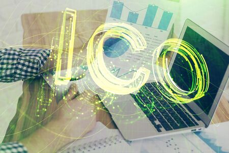 Crypto currency theme hologram with businessman working on computer on background. Concept of blockchain. Double exposure.の写真素材