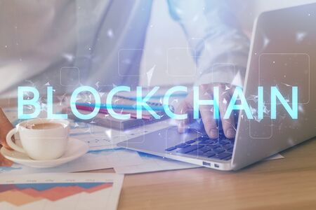Crypto currency theme hologram with businessman working on computer on background. Concept of...