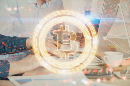 Crypto currency theme hologram with businessman working on computer on background. Concept of blockchain. Multi exposure.の写真素材