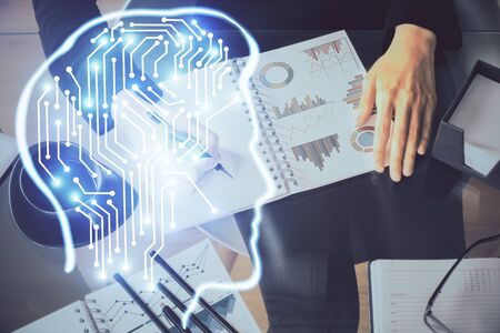 Multi exposure of woman's writing hand on background with brain hologram. Concept of brainstorming.の写真素材