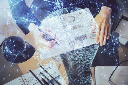 Multi exposure of womans writing hand on background with brain hologram. Concept of brainstorming.の写真素材