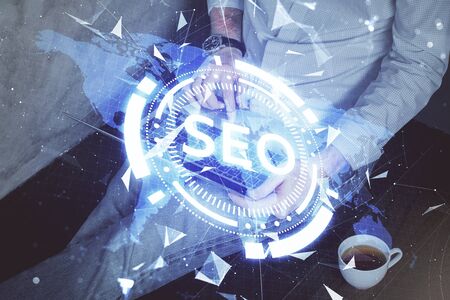 Multi exposure of seo icon with man working on computer on background. Concept of search engine optimization.の写真素材