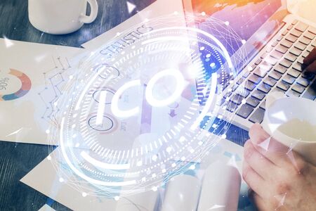 Crypto currency theme hologram with businessman working on computer on background. Concept of blockchain. Double exposure.の写真素材