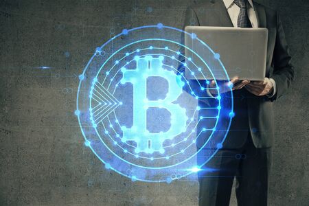 Crypto currency theme hologram with businessman working on computer on background. Concept of blockchain. Double exposure.の写真素材