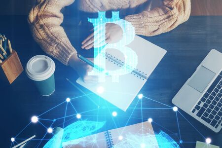 Cryptocurrency hologram over hands taking notes background. Concept of blockchain. Multi exposure