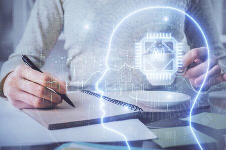 Double exposure of writing hand on background with brain hologram. Concept of learning.