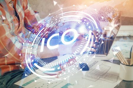 Crypto currency theme hologram with businessman working on computer on background. Concept of blockchain. Multi exposure.の写真素材