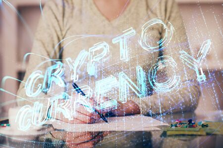 Cryptocurrency hologram over womans hands writing background. Concept of blockchain. Multi exposureの写真素材