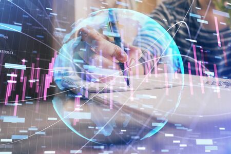 Financial forex graph drawn over hands taking notes background. Concept of research. Double exposureの写真素材