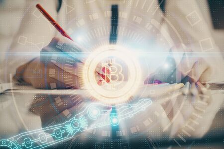 Cryptocurrency hologram over woman's hands writing background. Concept of blockchain. Double...