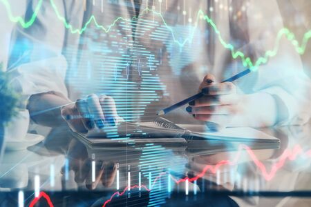Financial forex graph drawn over hands taking notes background. Concept of research. Double exposure