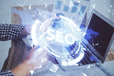 Multi exposure of seo icon with man working on computer on background. Concept of search engine optimization.の写真素材