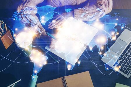 International business hologram over woman's hands taking notes background. Concept of success. Double exposureの写真素材