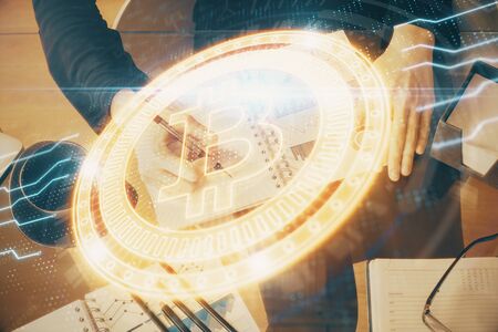 Cryptocurrency hologram over woman's hands writing background. Concept of blockchain. Double...