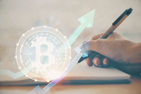 Cryptocurrency hologram over hands taking notes background. Concept of blockchain. Multi exposureの写真素材