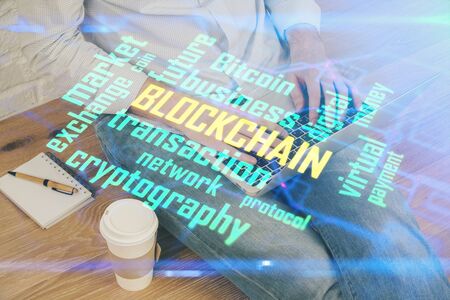 Crypto currency theme hologram with businessman working on computer on background. Concept of blockchain. Double exposure.の写真素材