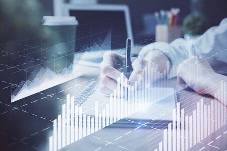 Forex chart displayed on woman's hand taking notes background. Concept of research. Double exposureの写真素材