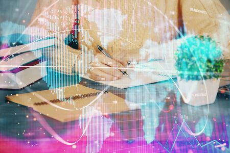 International business hologram over woman's hands taking notes background. Concept of success. Double exposureの写真素材