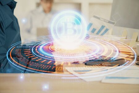 Crypto currency theme hologram with businessman working on computer on background. Concept of blockchain. Multi exposure.の写真素材