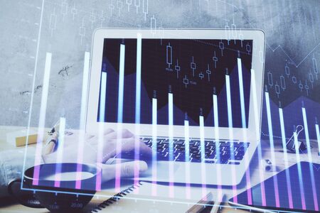 Forex graph with businessman working on computer in office on background. Concept of hardworking. Double exposure.の写真素材