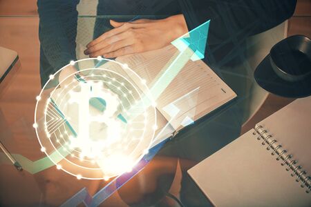 Cryptocurrency hologram over woman's hands writing background. Concept of blockchain. Multi exposureの写真素材