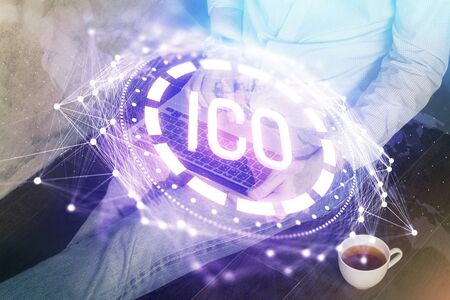 Crypto currency theme hologram with businessman working on computer on background. Concept of blockchain. Double exposure.の写真素材