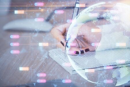 Multi exposure of hands making notes with world map hologram and data theme icons. Concept of global data.の写真素材
