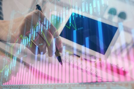 Financial forex graph drawn over hands taking notes background. Concept of research. Double exposureの写真素材