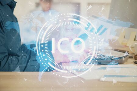 Crypto currency theme hologram with businessman working on computer on background. Concept of blockchain. Multi exposure.の写真素材